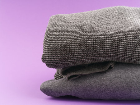 Neatly folded clothes on a uniform background. Space for textの写真素材