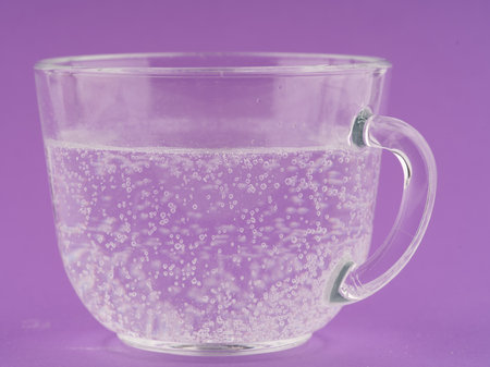 There is water in a clear glass with a tablet dissolved in it. Bubbles are visible. The concept of taking medicationsの写真素材