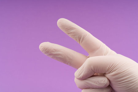 The concept of victory. A gloved hand shows a V sign
