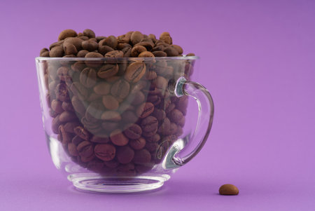 A transparent cup filled to the brim with coffee beans. Space for textの写真素材