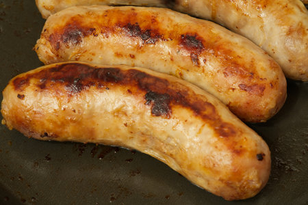 Sausages fried in a frying pan. Closeupの写真素材
