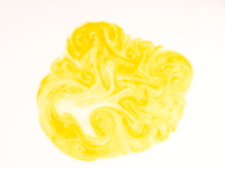 A stain of paint dissolved in a white liquid closeup. View from above. Abstractの写真素材