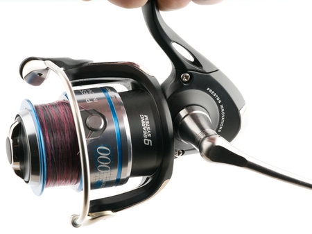 Moscow, Russia-October 16, 2022: Branded fishing reel in hand on a white backgroundのeditorial素材