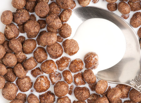 Chocolate breakfast in the form of balls in milk. And spoon. Closeupの写真素材