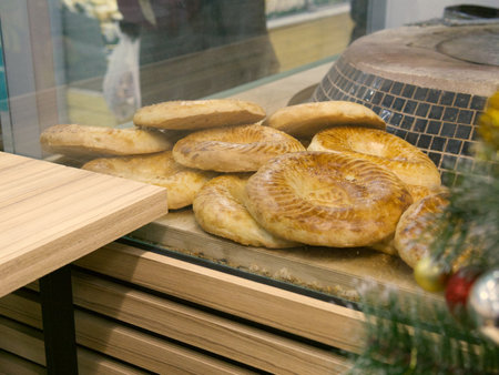 Freshly baked round bread in a bakery and a nearby oven for baking itの写真素材