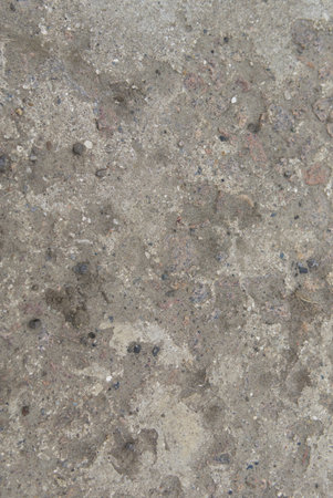 The texture of old concrete with stones frozen in it. Closeup. Vertical shot.の写真素材