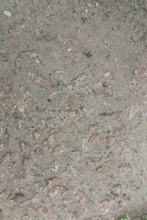 The texture of old concrete with stones frozen in it. Closeup. Vertical shot.の写真素材