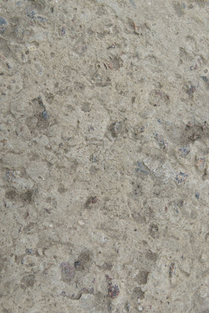 The texture of old concrete with stones frozen in it. Closeup. Vertical shot.の写真素材