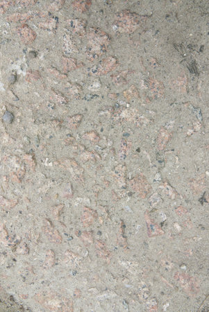 The texture of old concrete with stones frozen in it. Closeup. Vertical shot.の写真素材
