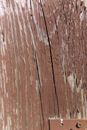 The texture of an old wooden board with peeling red paint. A vertical snapshot. Closeup.の写真素材