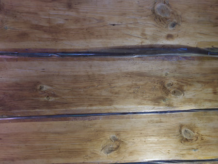 The texture of the wooden ceiling with taped tape to preserve heat. The boards go horizontally. Close.の写真素材