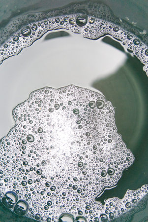 Detergent foam in a bucket of water. View from above. Vertical snapshot.の写真素材