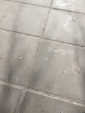 The texture of the tiles on the street is gray. The road is in the city. Vertical snap.の写真素材