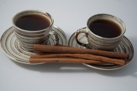 Two cups of tea  with cinnamon  on the white background .の写真素材