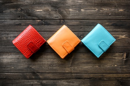 Group colorful Wallet of Leather skin on dark wooden backgroundの写真素材