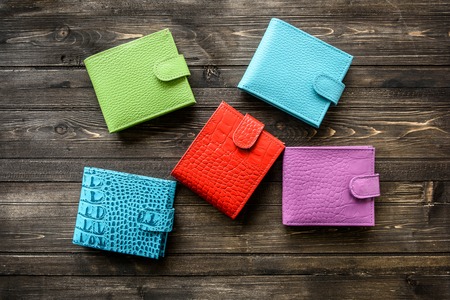 Group colorful Wallet of Leather skin on dark wooden backgroundの写真素材
