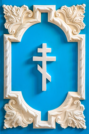 white Orthodox cross in the beautiful blue wooden frame.の写真素材
