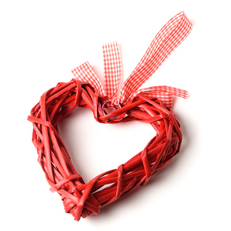 red decorative heart woven from vines on a white backgroundの写真素材