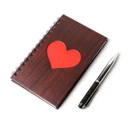 wooden texture notebook with red heart and pen on white backgroundの写真素材