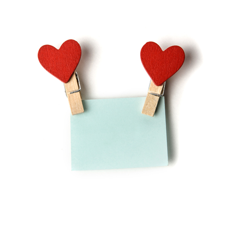 clothespins with red hearts holding a blue stickerの写真素材