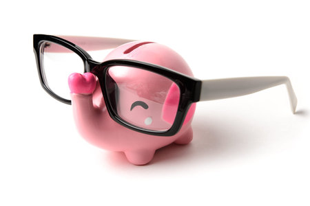 Pink elephant piggy bank with glasses isolated on a white backgroundの写真素材