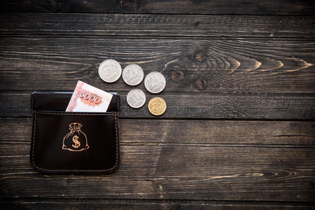 Stylish leather wallet with money and box on wooden background