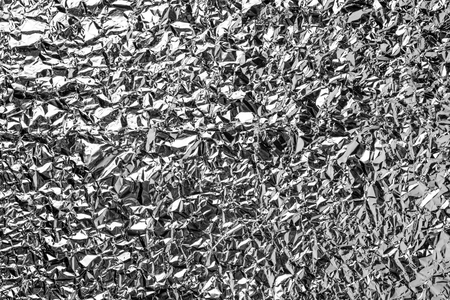 Silver foil background with shiny crumpled surface for texture backgroundの写真素材