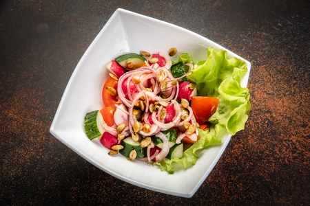 Fresh salad with mixed greens in bowl on wooden background.の写真素材