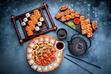 From above composition of various sushi rolls, green tea and chopsticks on marble backgroundの写真素材