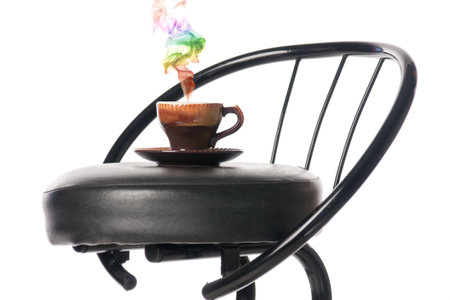 Coffee cup on a bar chair with a colour smoke. Isolated over white.の写真素材
