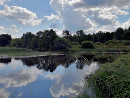 summer landscape with clouds in the riverの写真素材