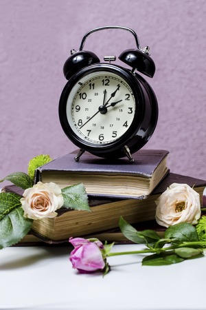 still life with alarm clock, books and flowersの写真素材