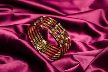 gold bracelet with diamonds on red silkの写真素材