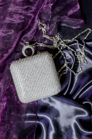 white clutch inlaid diamonds on silk backgroundの写真素材