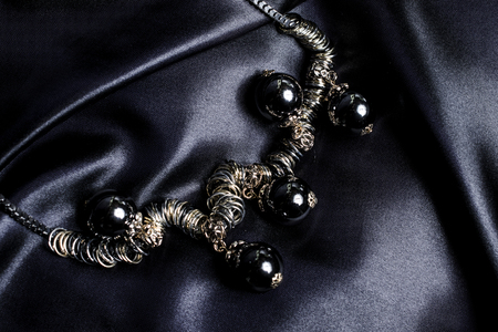 necklace with black beads on silk backgroundの写真素材
