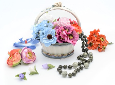 flowers and beads in a basket on whiteの写真素材