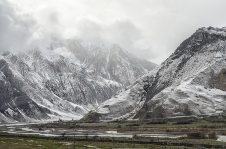 snowy mountain peak peaks of mountain surrounded by cloudsの写真素材