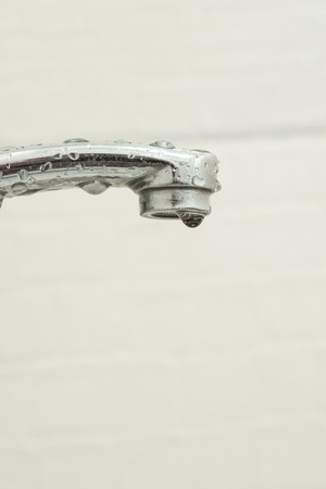 Faucet and water dropの写真素材