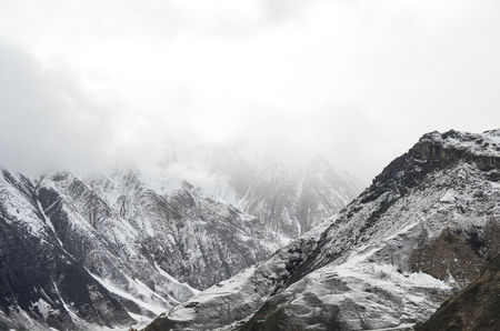 snowy mountain peak peaks of mountain surrounded by cloudsの写真素材