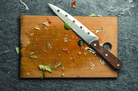 Dirty kitchen chopping board and knife.