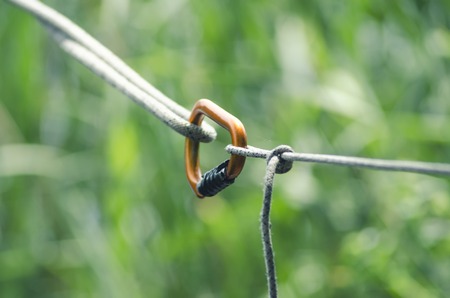 Climbing carabiners with rope on green background, strong connectionの写真素材