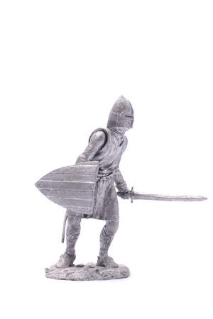 tin soldier medieval knight with sword and shield isolated on whiteの写真素材