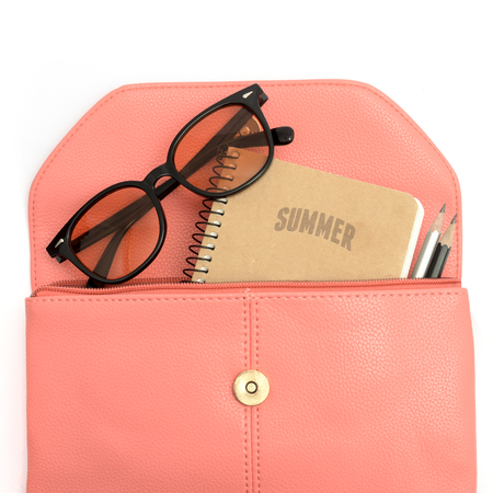 Notebook sunglasses and pensils in pink leather bagの写真素材