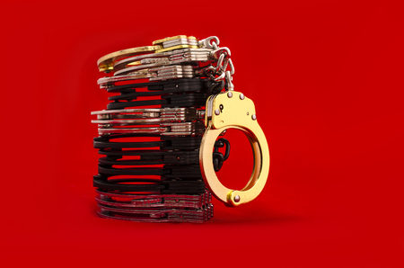 Handcuffs on a red backgroundの写真素材
