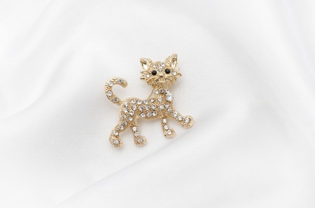 Brooch golden kitten with diamonds on silk fabricの写真素材