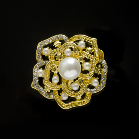 gold brooch flower with pearl isolated on blackの写真素材