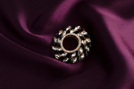 round brooch with gems isolated on silk