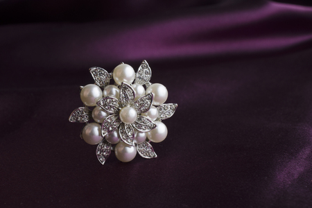 brooch heart with diamonds and pearls isolated on silkの写真素材