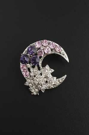 silver brooch month with stars with diamonds isolated on blackの写真素材