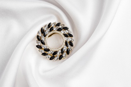 round brooch with gems isolated on silkの写真素材